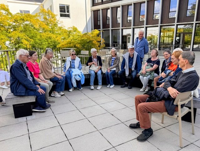 De groep in gesprek tijdens een pauze op het dakterras.